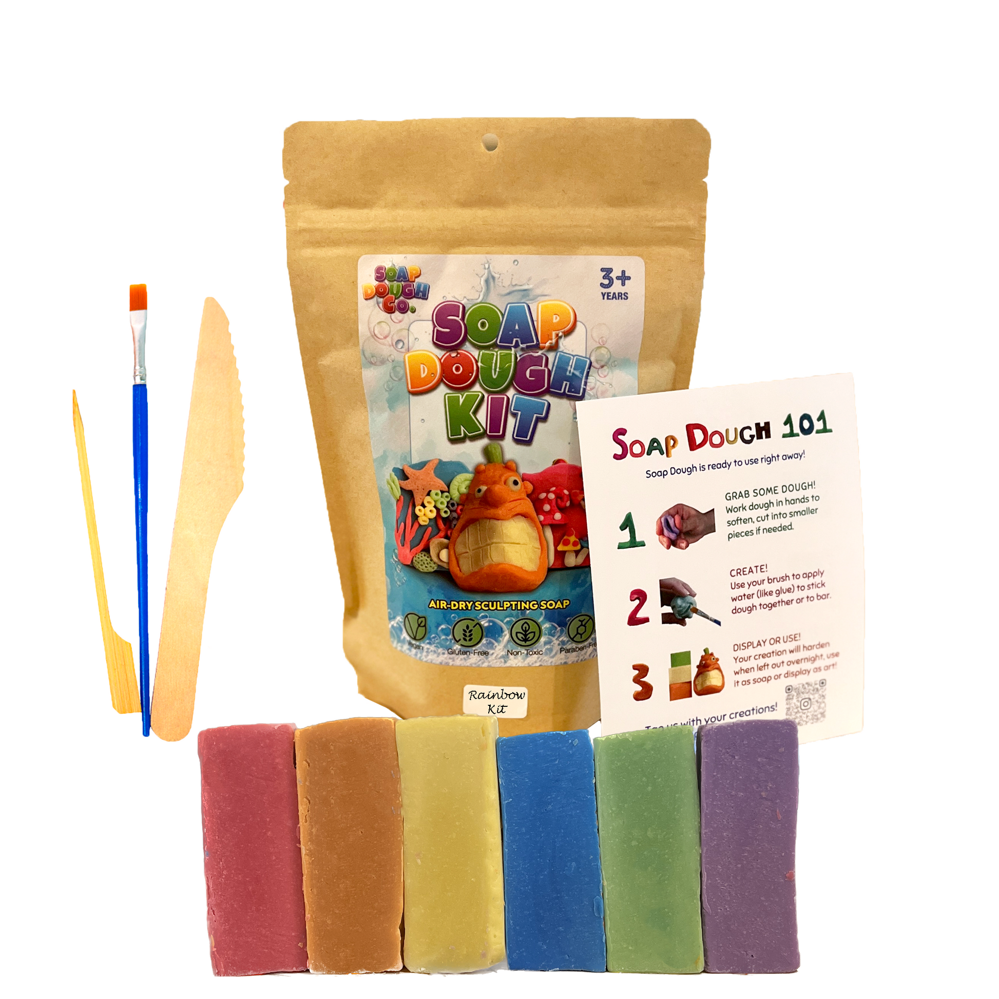 Soap Dough Co. - Rainbow Kit - Wall of yellow, purple, green, orange, blue, and red with eco-bag, instructions, and tools next to soap dough.
