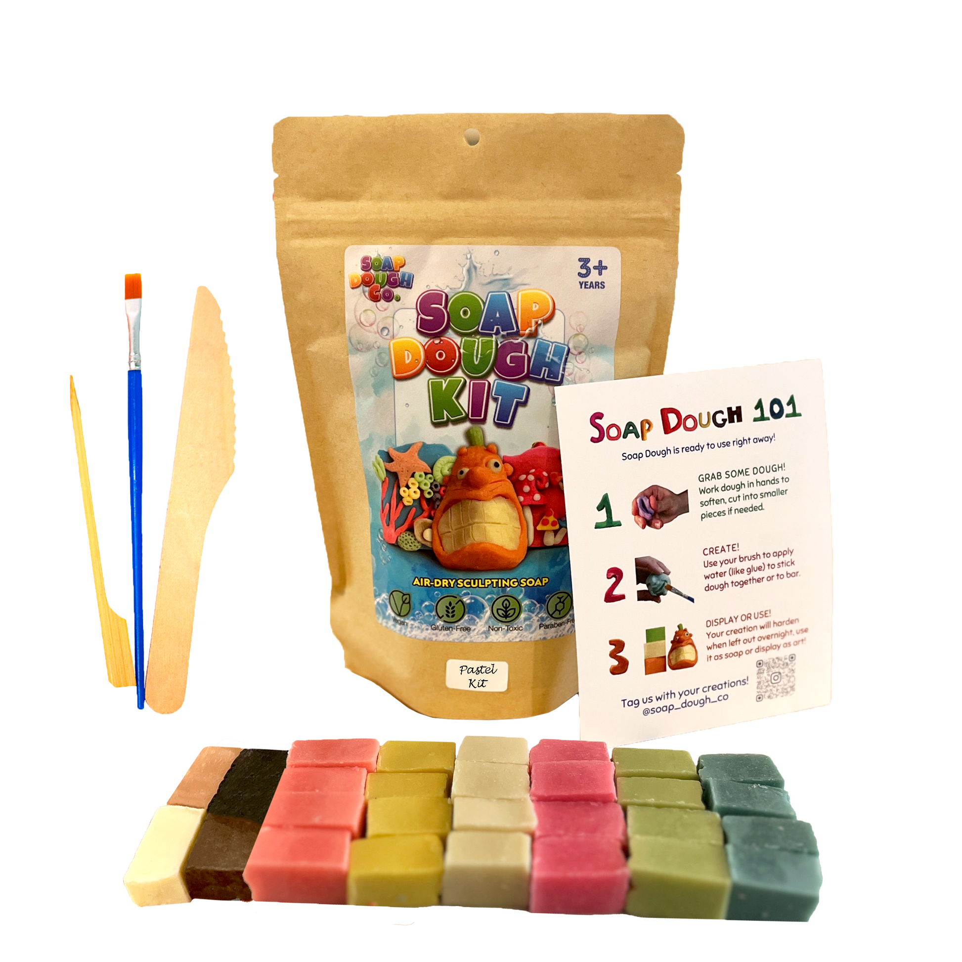 Soap Dough Co. - Pastel Kit - Wall of pastel yellow, pink, green, orange, blue, and white with eco-bag, instructions, and tools next to soap dough cubes with accent colors.