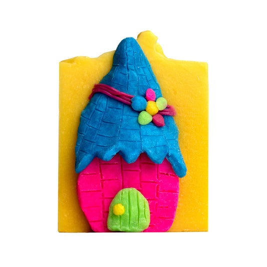 Photo of lemongrass canvas soap bar with soap dough sculpture of gnome and fairy house in blue and pink soap dough with green soap dough door.